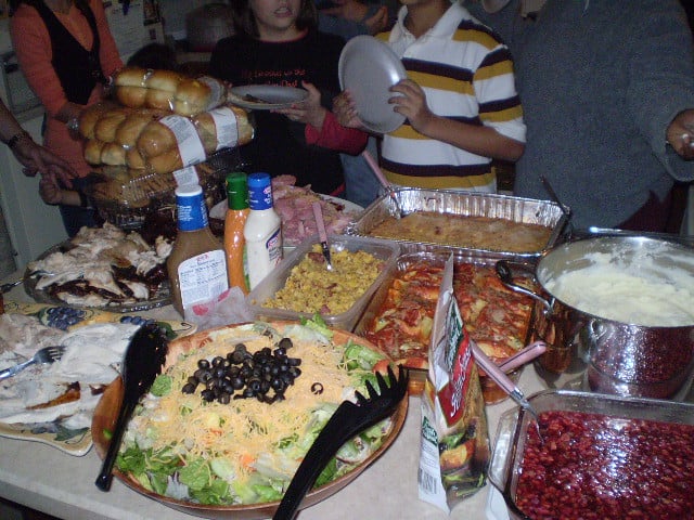 A table of thanksgiving potluck diner foods.