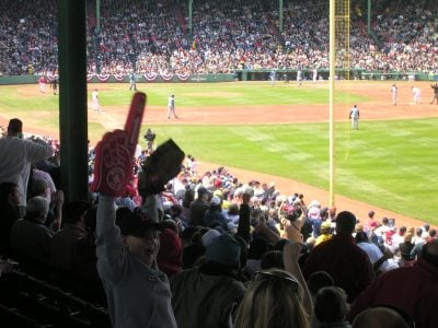 Fan with foam finger at baseball game.