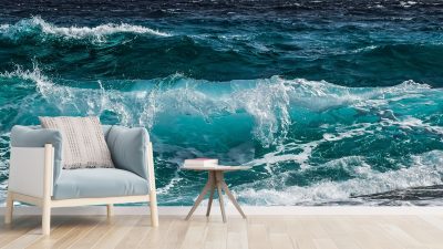 Cozy living room chair and side table in front of an ocean wall mural.