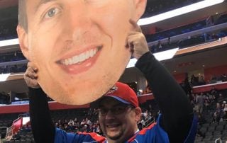 Fan holding BigHead at a NBA game.