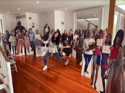 Woman in living room surrounded by life size Cardboard Cutout Standees of friends & family.