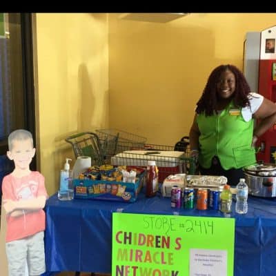 Donations table display with snacks, store employee and patient ambassador cutout.