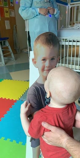 Jake hugging cardboard cutout of Max in hospital.