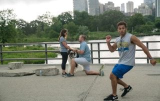 Photobomber runs in front of couple getting engaged on bridge.
