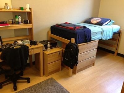 Dorm room with a study nook area.