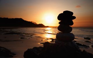 Stacked zen stones on a sunset beach.
